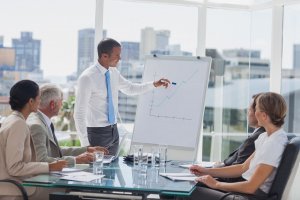 Manager pointing at the peak of a chart during a meeting in the meeting room